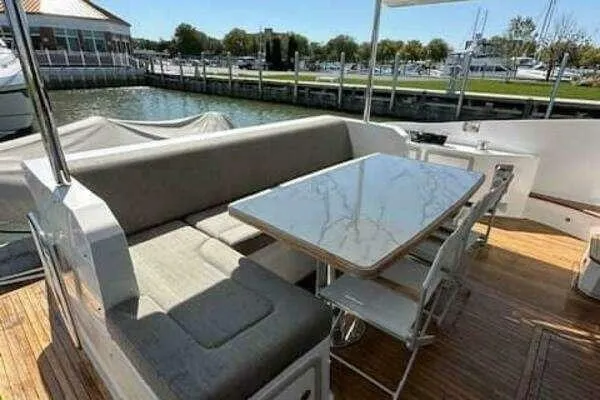 Slide: The Image of Outdoor seating area on a 2020 Azimut 66 yacht, featuring a table and cushioned bench. - 24