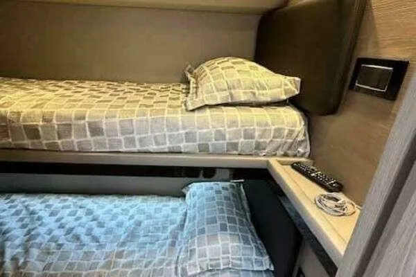 Slide: The Image of Bunk beds in 2020 Azimut 66 yacht cabin with remote control on shelf. - 49