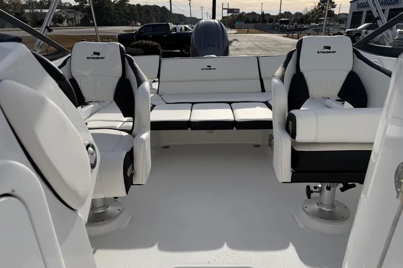 Slide: The Image of 2026 Stingray 211 DC boat interior with white and black seating arrangement. - 11