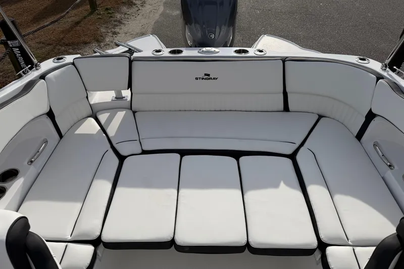 Slide: The Image of 2026 Stingray 211 DC boat interior with spacious white seating and cup holders. - 14