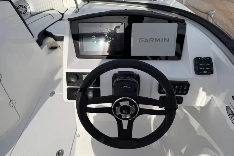Slide: The Image of 2026 Stingray 211 DC boat dashboard with Garmin navigation system and steering wheel. - 15