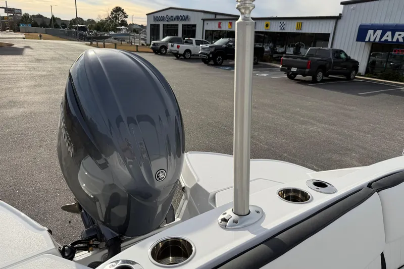 Slide: The Image of 2026 Stingray 211 DC boat with Yamaha outboard motor in dealership parking lot. - 16