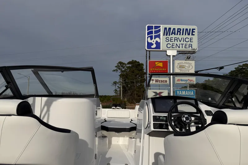 Slide: The Image of 2026 Stingray 211 DC boat at Marine Service Center with signage in background. - 17