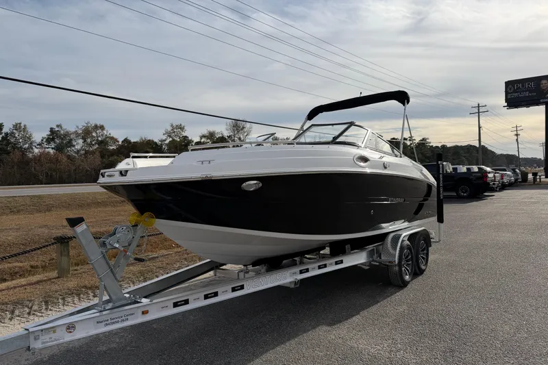 Slide: The Image of 2026 Stingray 211 DC boat on trailer, parked outdoors under cloudy sky. - 2