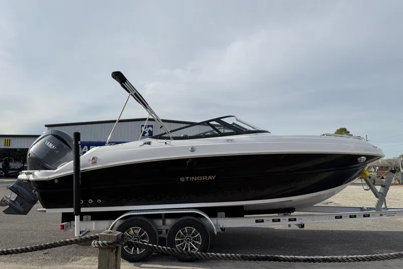 Slide: The Image of 2026 Stingray 211 DC boat on trailer, sleek black and white design, Yamaha engine. - 4
