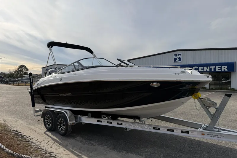 Slide: The Image of 2026 Stingray 211 DC boat on trailer at a marine service center. - 5