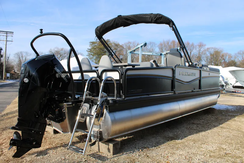 Slide: The Image of 2026 Premier 230 Sunsation RS pontoon boat with Mercury outboard engine, parked outdoors. - 2