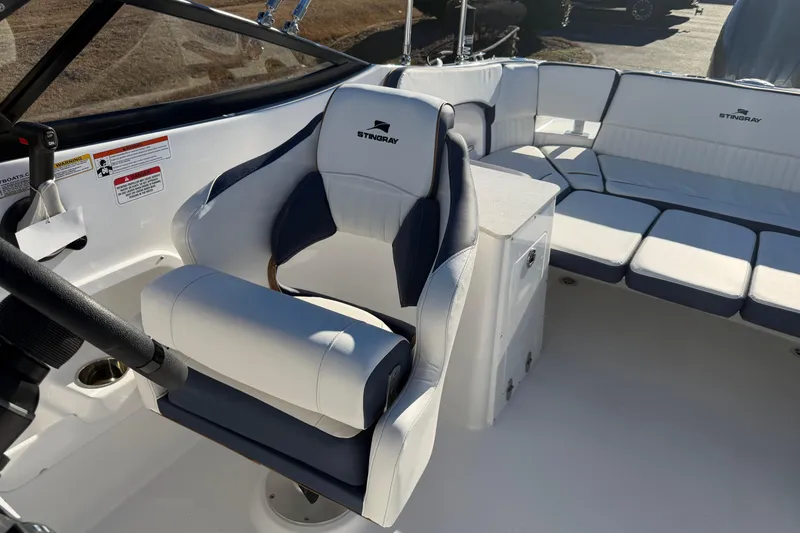 Slide: The Image of 2026 Stingray 231 DC boat interior with white and navy seating, steering wheel, and console. - 12