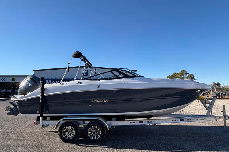 Slide: The Image of 2026 Stingray 231 DC boat on trailer under clear blue sky. - 4