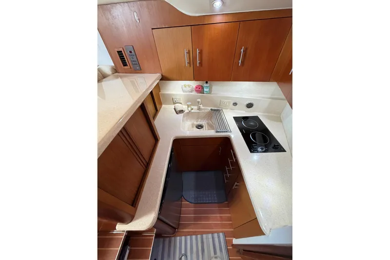 Slide: The Image of Compact kitchen in 2001 Ocean Yachts 40 Super Sport with modern appliances and wooden cabinetry. - 12