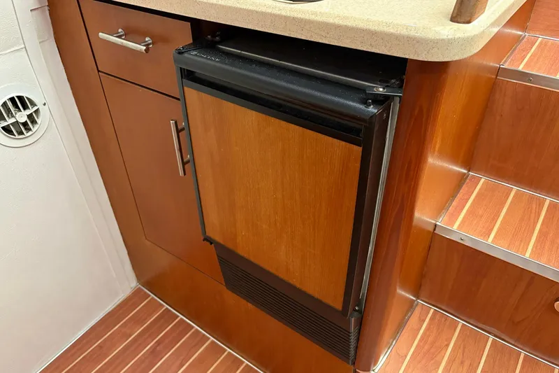 Slide: The Image of Wooden interior of 2001 Ocean Yachts 40 Super Sport, featuring compact fridge and cabinetry. - 14