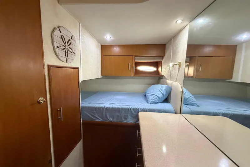 Slide: The Image of 2001 Ocean Yachts 40 Super Sport cabin with bed, wooden cabinets, and decorative wall art. - 20