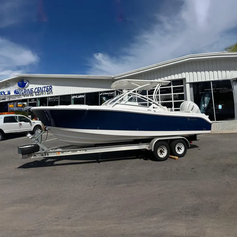 The Image of 2025 Edgewater 248CX Crossover boat on trailer outside marine center. - 0