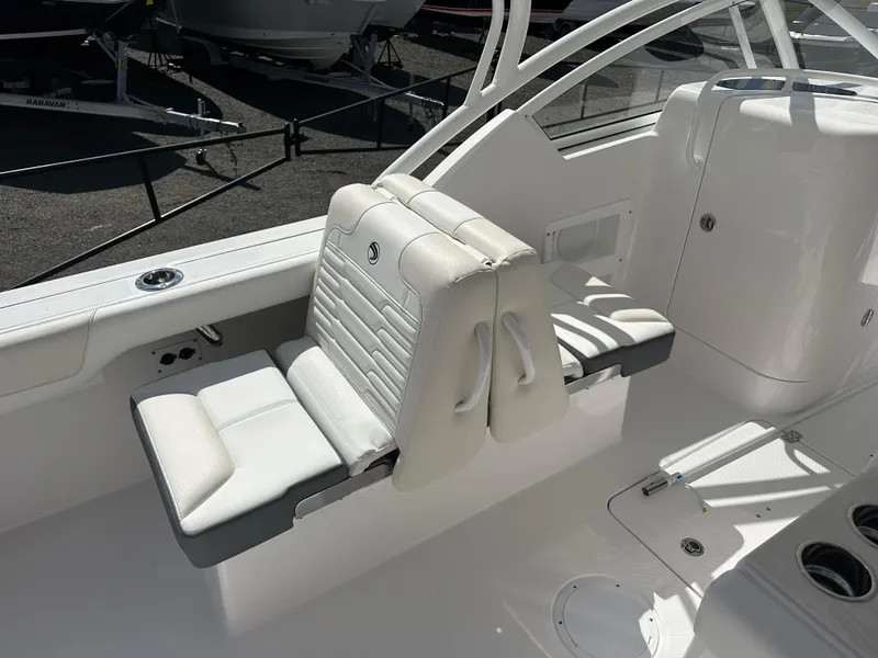 Slide: The Image of 2025 Edgewater 248CX Crossover boat interior with white seating and modern design. - 14