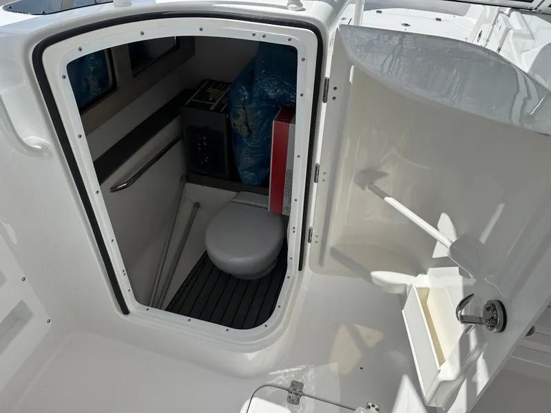 Slide: The Image of 2025 Edgewater 248CX Crossover boat interior with compact marine toilet. - 20