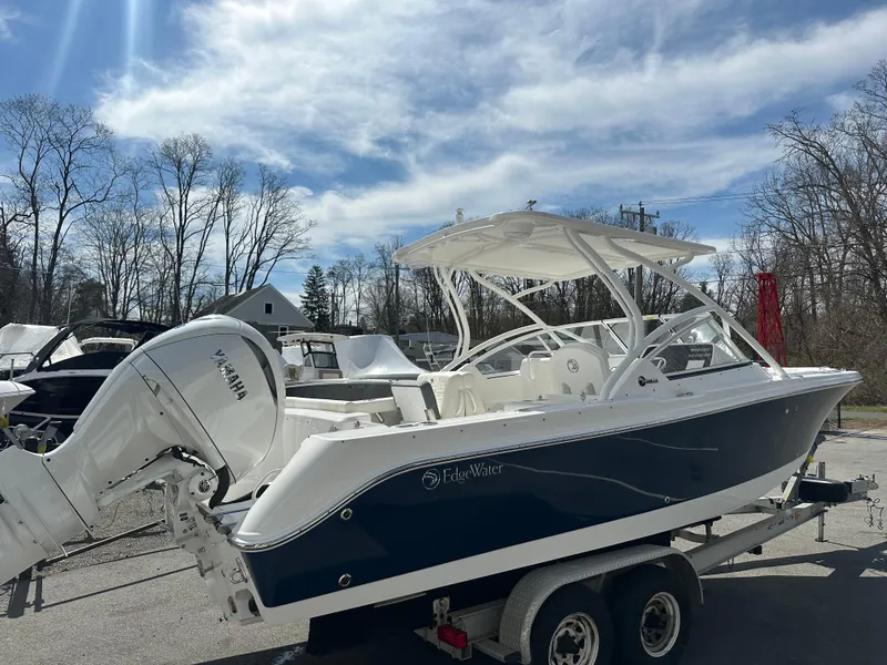 Slide: The Image of 2025 Edgewater 248CX Crossover boat on trailer under a cloudy sky. - 3
