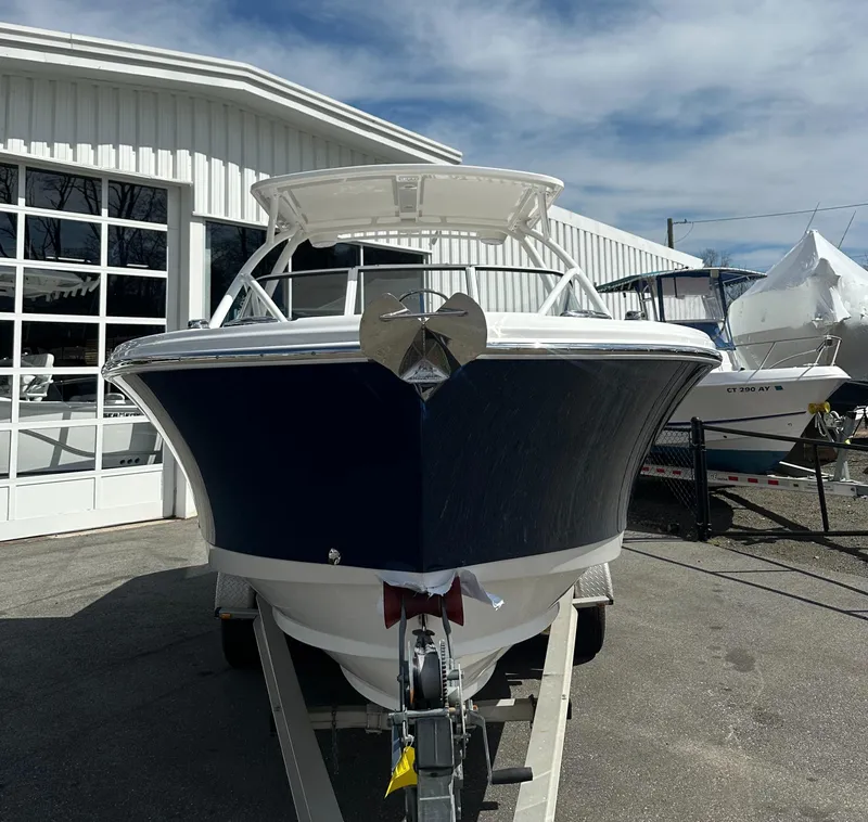 Slide: The Image of 2025 Edgewater 248CX Crossover boat on trailer, parked outside a white building. - 5