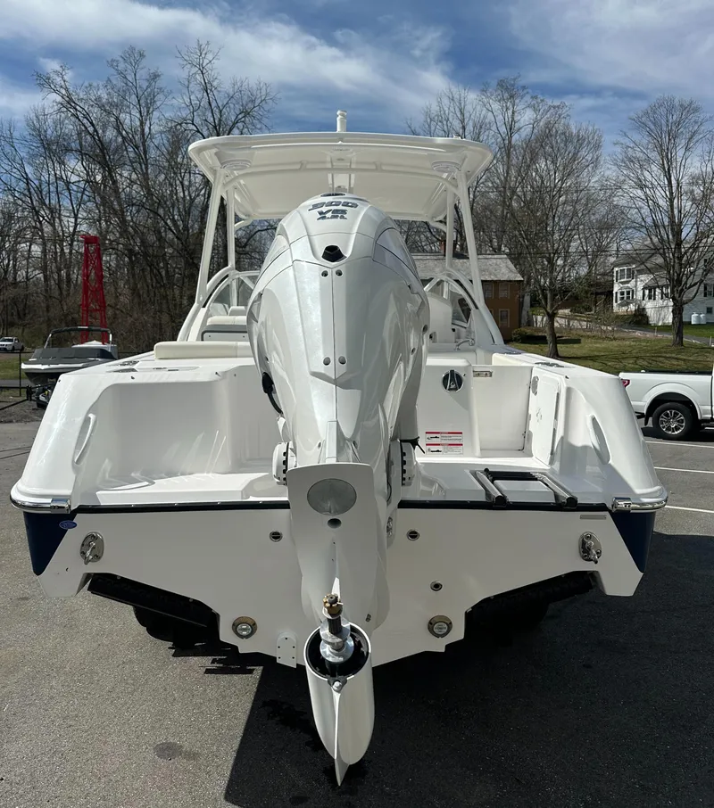 Slide: The Image of 2025 Edgewater 248CX Crossover boat, rear view, parked outdoors on a sunny day. - 6