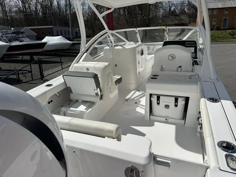 Slide: The Image of 2025 Edgewater 248CX Crossover boat interior with seating and storage, docked outdoors. - 8