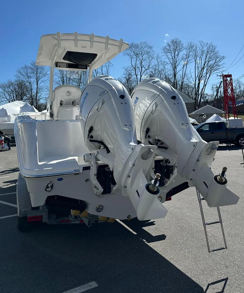 Slide: The Image of 2025 Edgewater 262 Center Console boat with dual outboard engines, parked outdoors. - 7