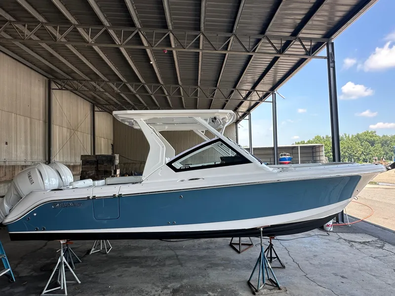 The Image of 2026 Edgewater 262CX Crossover boat in a covered storage area, side view. - 0