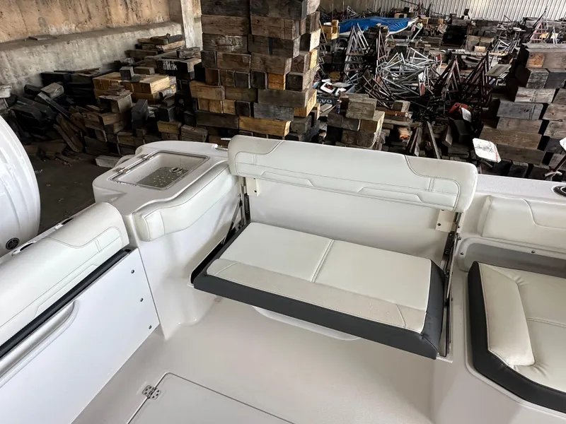 Slide: The Image of 2026 Edgewater 262CX Crossover boat interior with white seating and storage area. - 13