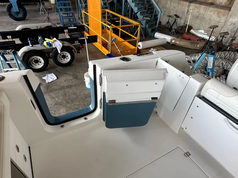 Slide: The Image of 2026 Edgewater 262CX Crossover boat interior with open door and visible equipment. - 15