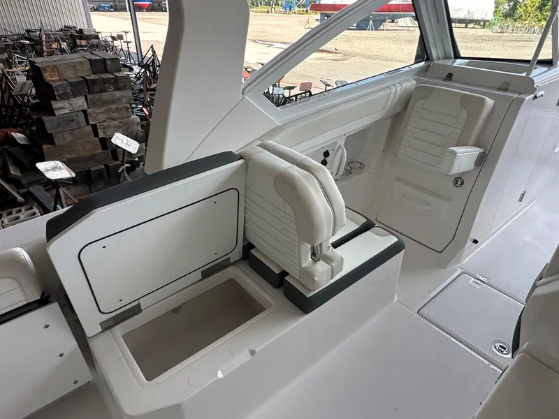 Slide: The Image of Interior of 2026 Edgewater 262CX Crossover boat with white seating and storage compartments. - 18