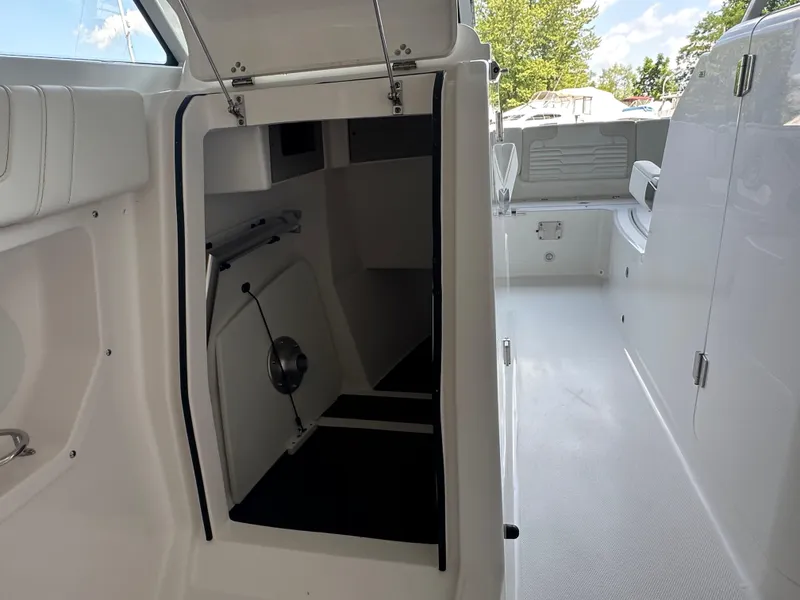 Slide: The Image of 2026 Edgewater 262CX Crossover boat interior with open storage compartment and seating area. - 21