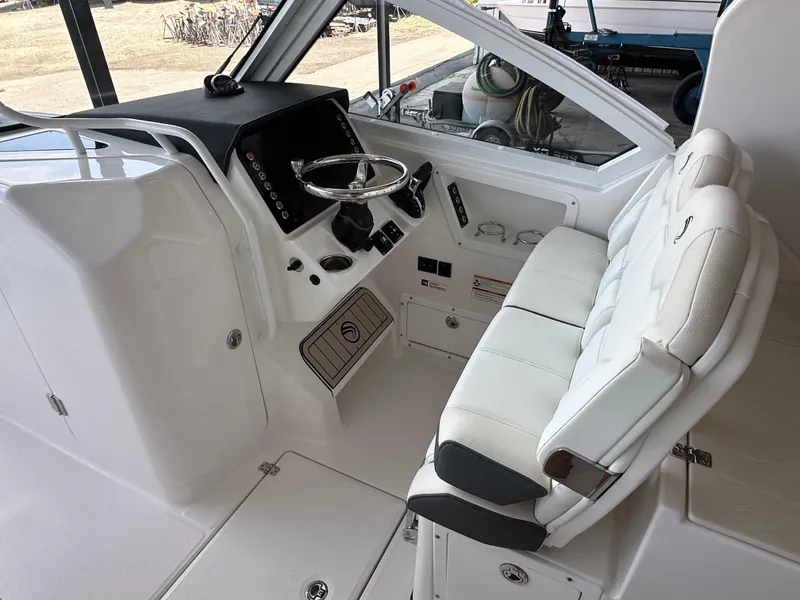 Slide: The Image of Interior of 2026 Edgewater 262CX Crossover boat with white seating and modern dashboard. - 22