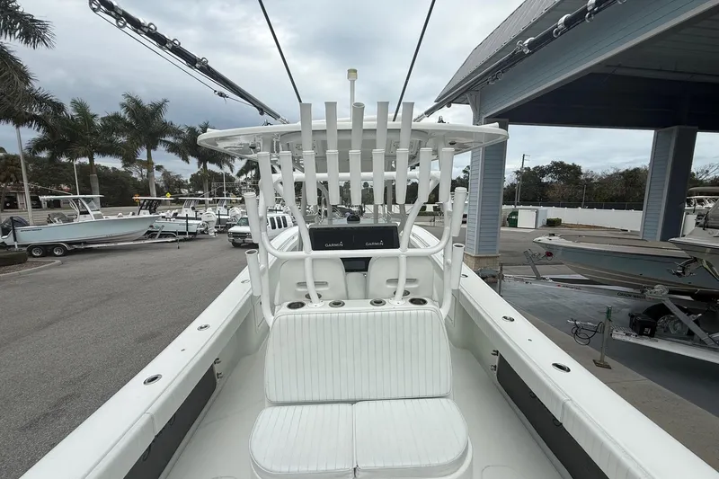 Slide: The Image of 2007 Yellowfin 34 Offshore boat with white seating and rod holders, docked near palm trees. - 11