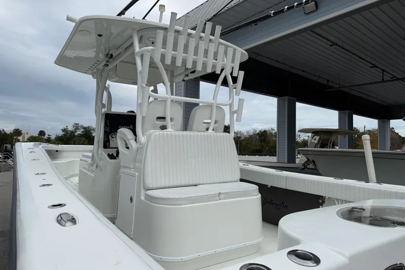 Slide: The Image of 2007 Yellowfin 34 Offshore boat with white seating and rod holders under a covered dock. - 13