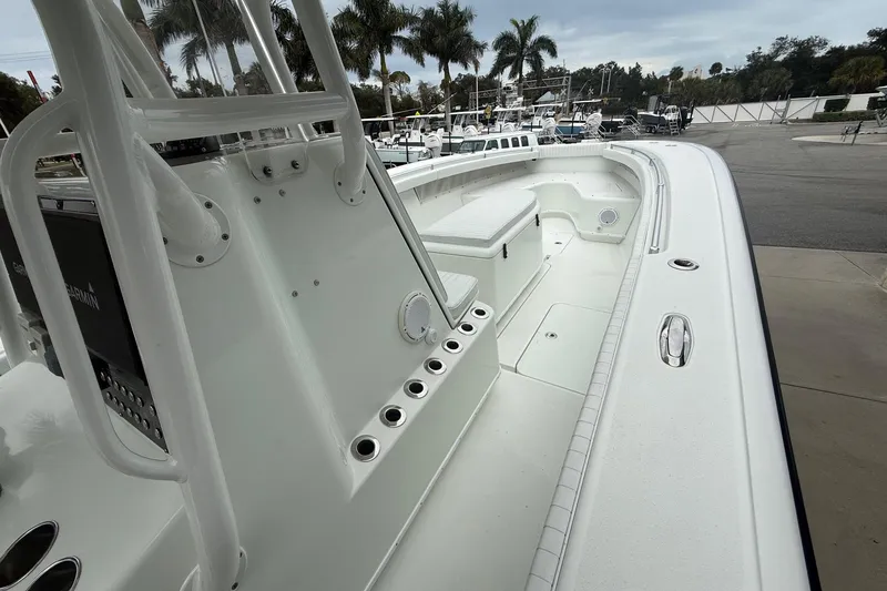 Slide: The Image of 2007 Yellowfin 34 Offshore boat interior with seating and rod holders, docked near palm trees. - 7