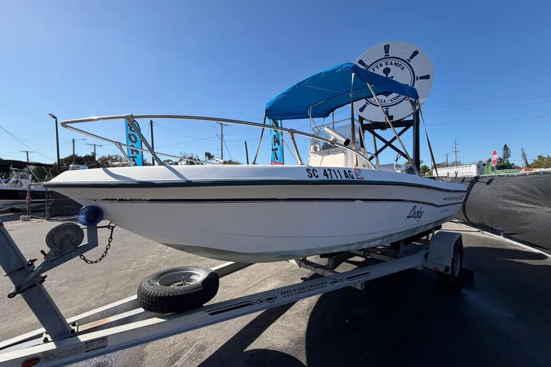 Slide: The Image of 1991 Grady-White Spirit 175 boat on trailer with blue canopy, parked outdoors. - 10