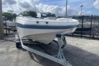 Slide: The Image of 2022 Hurricane SunDeck 192 OB boat on trailer, parked outdoors under cloudy sky. - 2