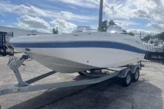 Slide: The Image of 2022 Hurricane SunDeck 192 OB boat on trailer, parked outdoors under a cloudy sky. - 3