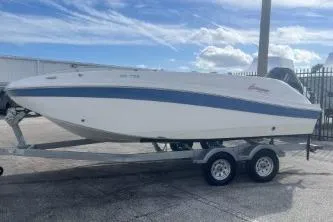 Slide: The Image of 2022 Hurricane SunDeck 192 OB boat on trailer, parked outdoors under a cloudy sky. - 4