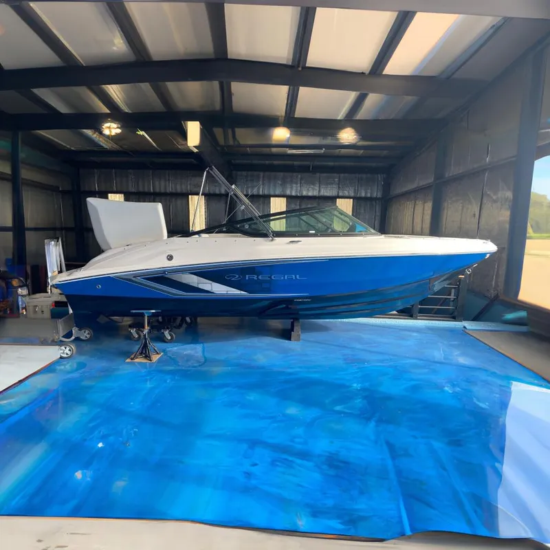 The Image of 2025 Regal 2000 ESX Bowrider in a garage on blue tarp. - 0