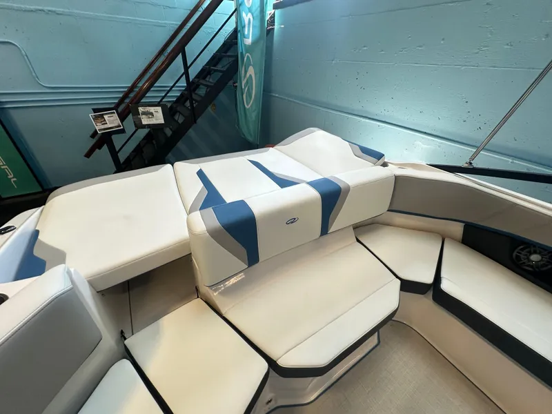 Slide: The Image of 2025 Regal 2000ES Bowrider interior with white and blue seating, showcased indoors. - 10