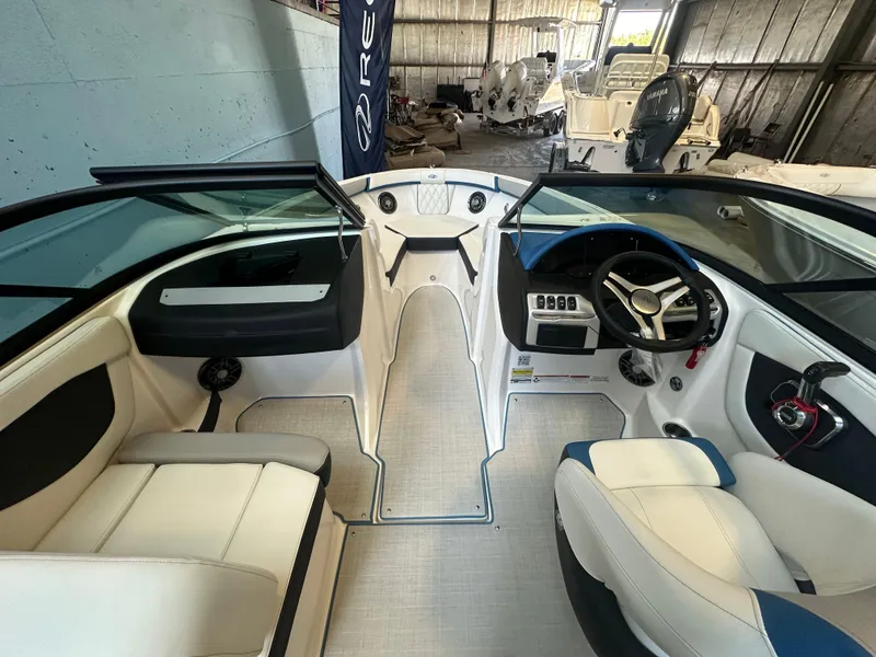Slide: The Image of 2025 Regal 2000ES Bowrider interior with modern seating and steering wheel in a showroom. - 15