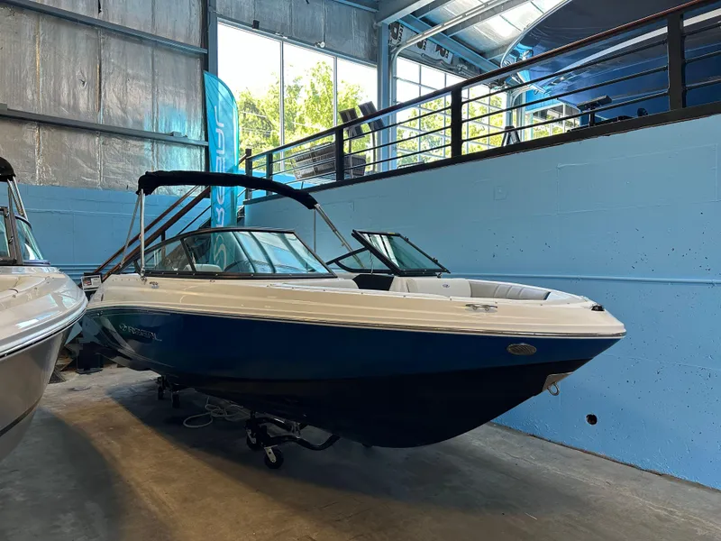 Slide: The Image of 2025 Regal 2000ES Bowrider boat in showroom, blue and white exterior. - 4