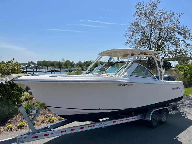 Slide: The Image of 2018 Sailfish 275 DC boat on trailer, sunny day. - 2