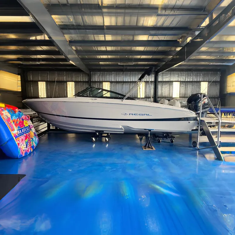 The Image of 2025 Regal LX2 boat in a warehouse on blue flooring. - 0