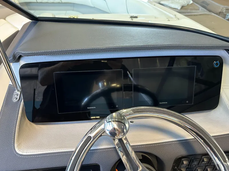 Slide: The Image of Dashboard of 2025 Regal LX2 boat with dual Garmin displays and steering wheel. - 15