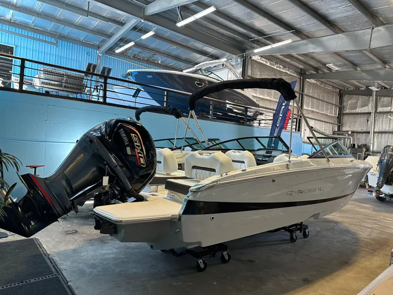 Slide: The Image of 2025 Regal LX2 boat in showroom with powerful outboard motor. - 6