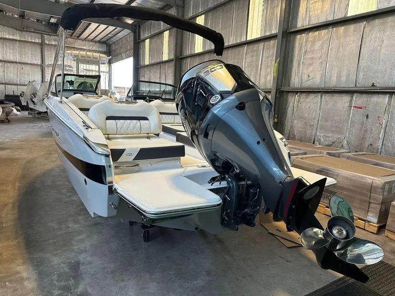 Slide: The Image of 2025 Regal LX2 boat with powerful outboard motor in a storage facility. - 7