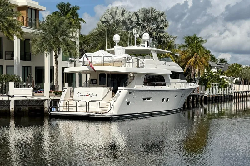 Slide: The Image of 2014 Pacific Mariner 85 Motor Yacht docked by palm trees and luxury home. - 2
