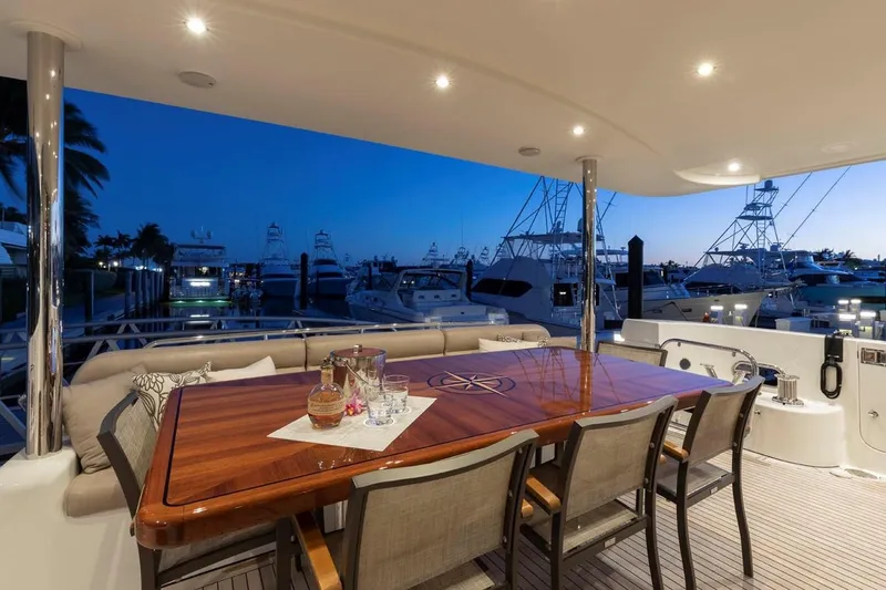 Slide: The Image of Luxurious 2014 Pacific Mariner 85 Motor Yacht deck with elegant dining setup at sunset. - 21