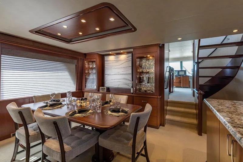 Slide: The Image of Luxurious dining area in 2014 Pacific Mariner 85 Motor Yacht, featuring elegant table settings and wood finishes. - 27