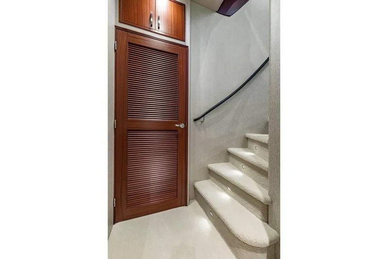 Slide: The Image of Interior staircase of 2014 Pacific Mariner 85 Motor Yacht with wooden door and carpeted steps. - 44